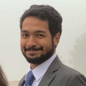 A man in a suit and tie smiles for photo.